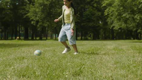 a girl playing soccer in the park