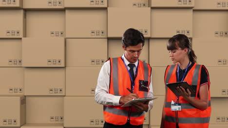 animación de trabajadores de almacén masculinos y femeninos usando tableta con pilas de cajas en el fondo