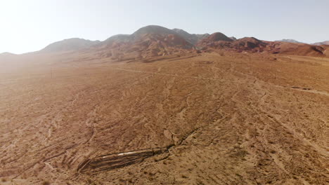 aerial shots of the barren, sandy, rocky, mountain filled, mojave desert on a sunny day