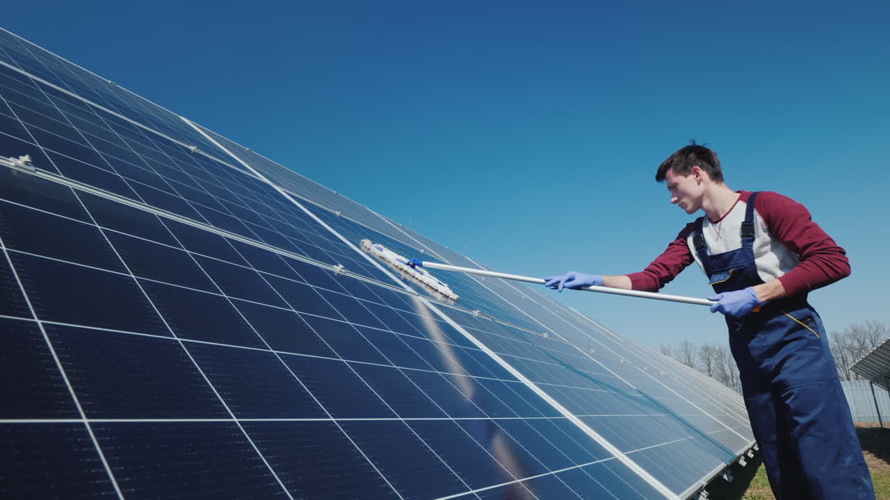 vista lateral del hombre lavando paneles solares en la planta de energía doméstica 1