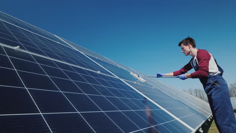 vista lateral del hombre lavando paneles solares en la planta de energía doméstica 1