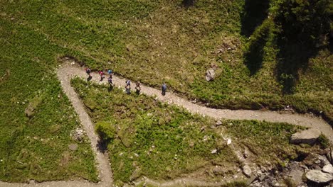 Senderismo-Familiar-En-Los-Alpes-Suizos,-Vista-Superior-Por-Drone