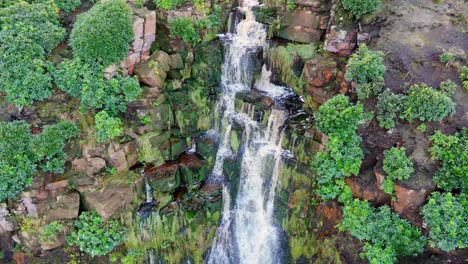 Atemberaubender-Wasserfall-Der-Yorkshire-Moors,-Luftaufnahme-Zeigt-Wasser,-Das-über-Felsen-In-Ein-Tiefes-Becken-Stürzt,-Darunter-Wanderer