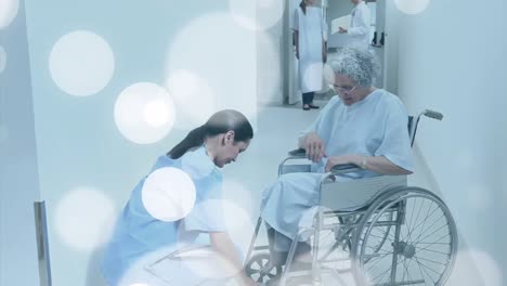 animation of spots over caucasian nurse with patient in wheelchair