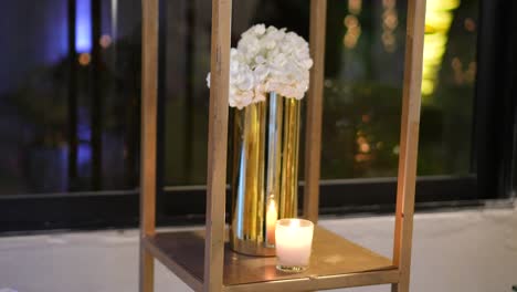 Decoración-De-Boda-Con-Jarrón-Dorado-Y-Flores-De-Hortensia-Con-Velas-Encendidas