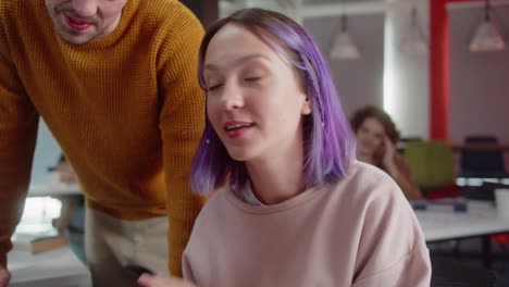 estudiantes jóvenes están sentados en el aula juntos, viendo videos divertidos y sonriendo, de cerca