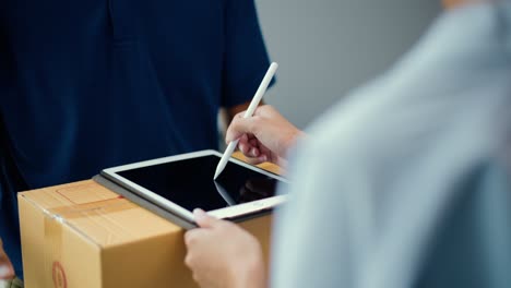 hand woman signing electronic signature on tablet for agreement of contract digital receiving parcel from blue delivery man from shopping online. courier man delivering package to destination.