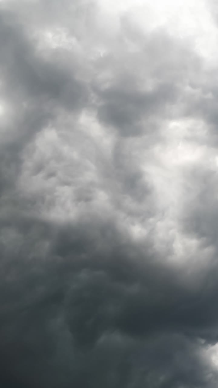 Awan badai gelap berkumpul di langit. Tetesan hujan jatuh ke kamera. Tampilan dari bawah. Selang waktu