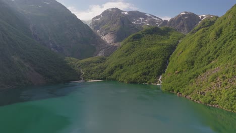 blue deep lake and mountains in norway, aerial ascend view