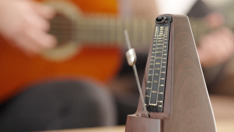 acoustic guitar playing in synchrony with classic metronome