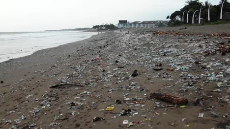 pull back shot of a disgustingly polluted beach, plastic waste dumped in the ocean washed out by the ocean