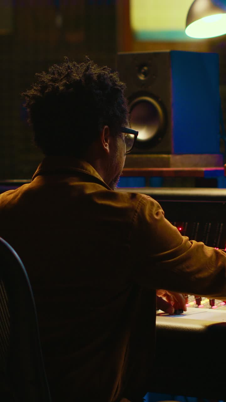 Uomo che modifica il mixer audio in uno studio di registrazione professionale