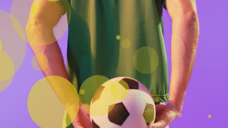 animation of lens flares over midsection of caucasian player hiding soccer ball