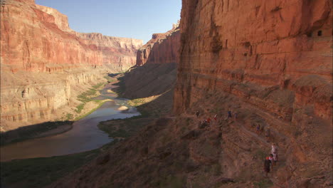 hikers on a narrow trail along a cliff in the grand canyon 1