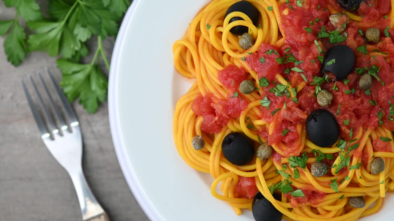 Pasta alla puttanesca italiana con salsa di pomodoro, capperi e olive nere