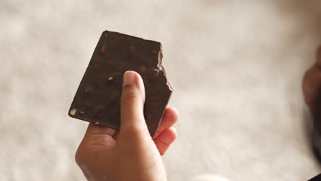 persona comiendo un pedazo de chocolate