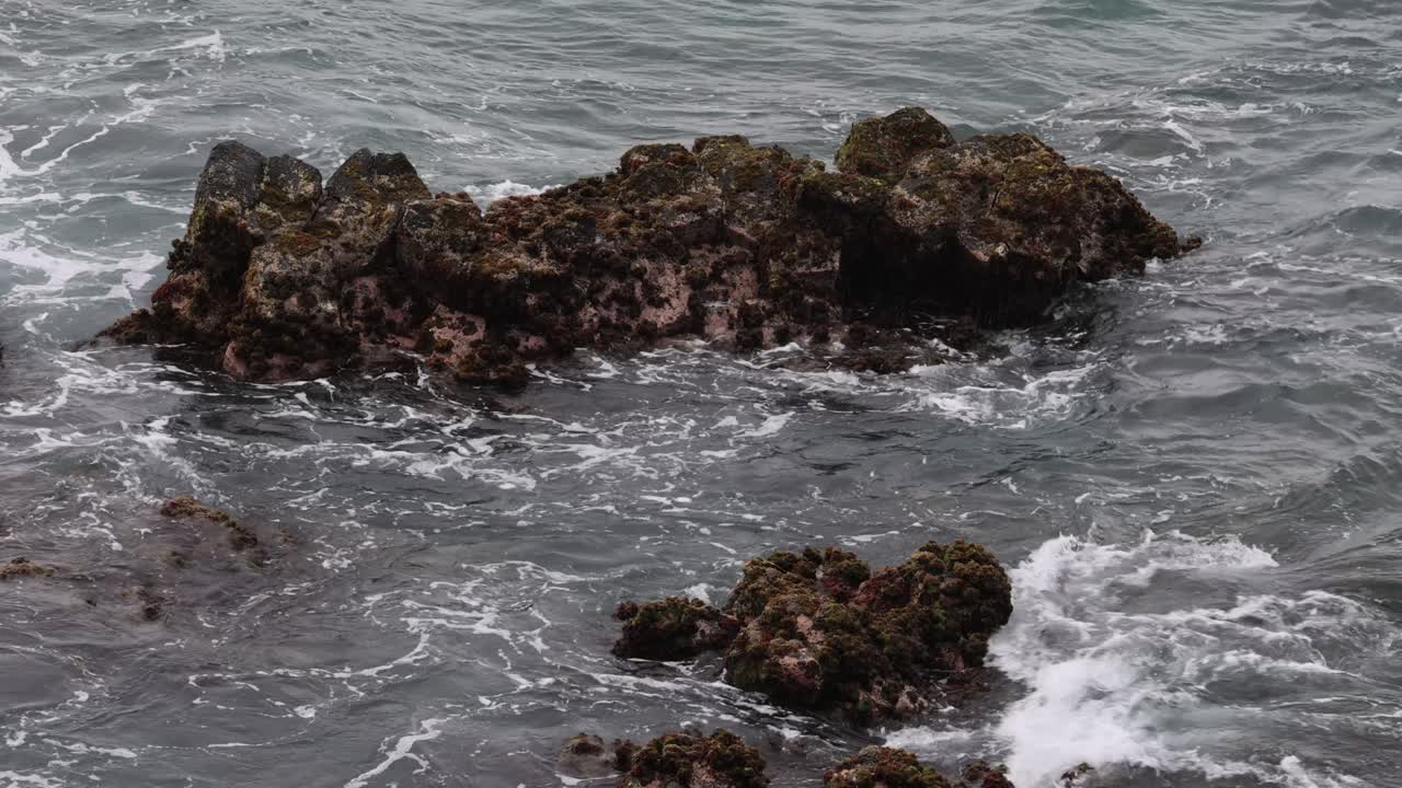 las olas interactúan con la costa rocosa con el tiempo
