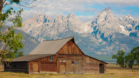 historic wooden barn with grand teton mountains in wyoming