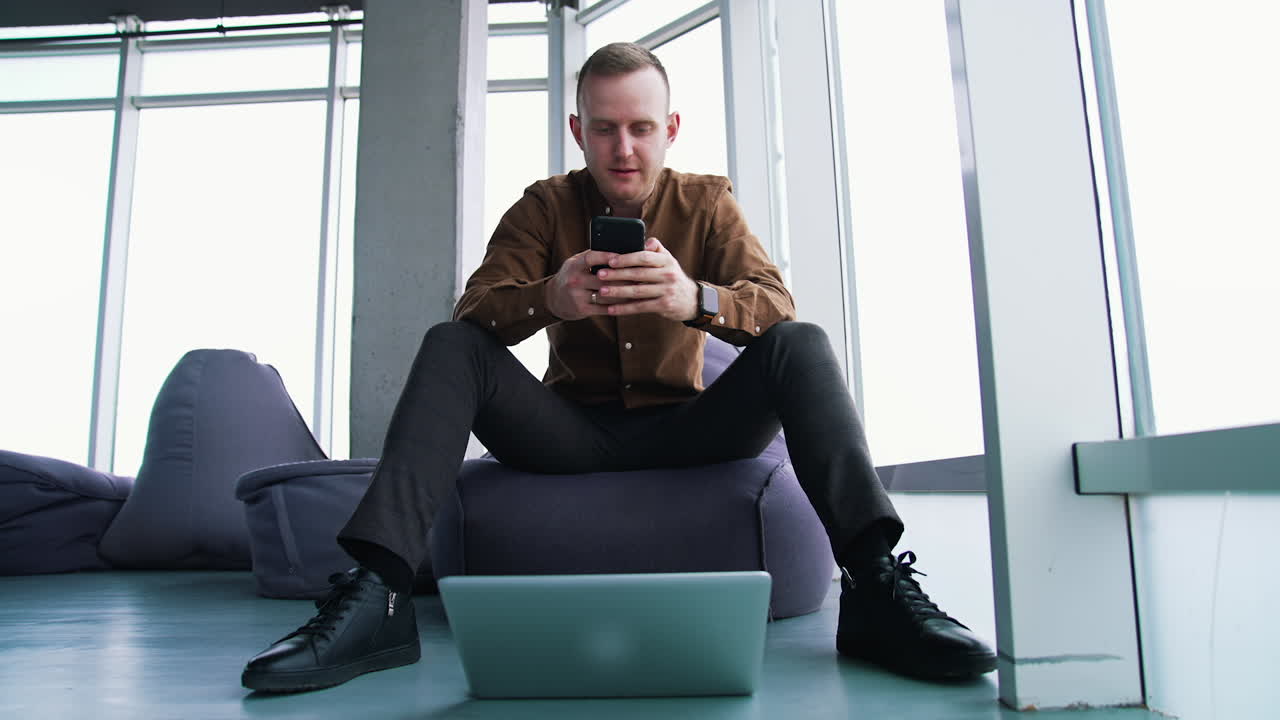 Young man with laptop and mobile phone. Man an is working remotely