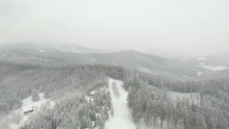 aerial view over czech mountains, on grey, snowy winter day in kohutka