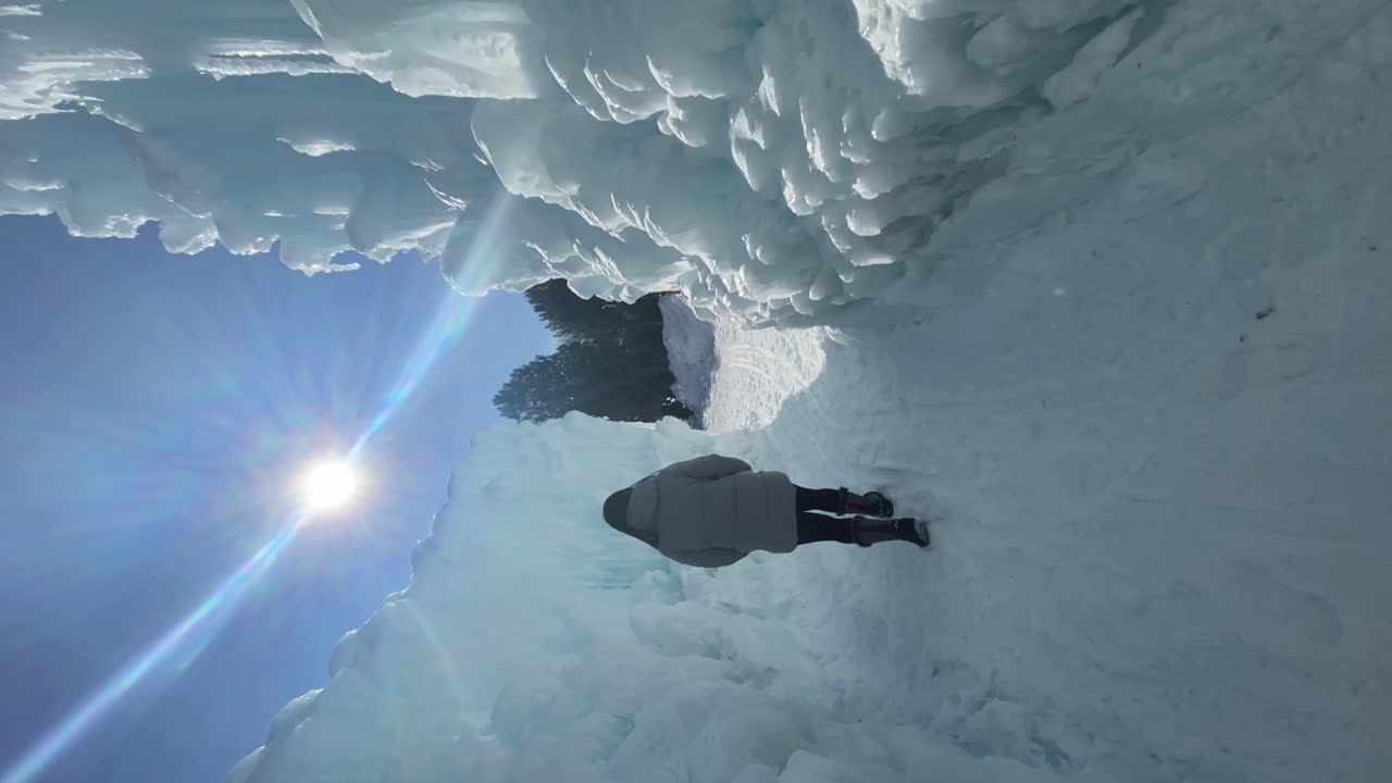 Vertical travel video woman exploring the Ice Castles