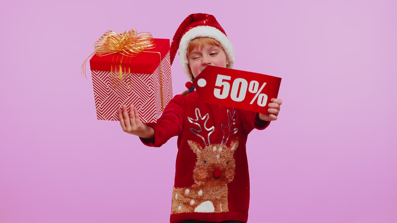 niña con sombrero de navidad mostrando caja de regalos y inscripciones de descuento del 50 por ciento nota de texto de banner