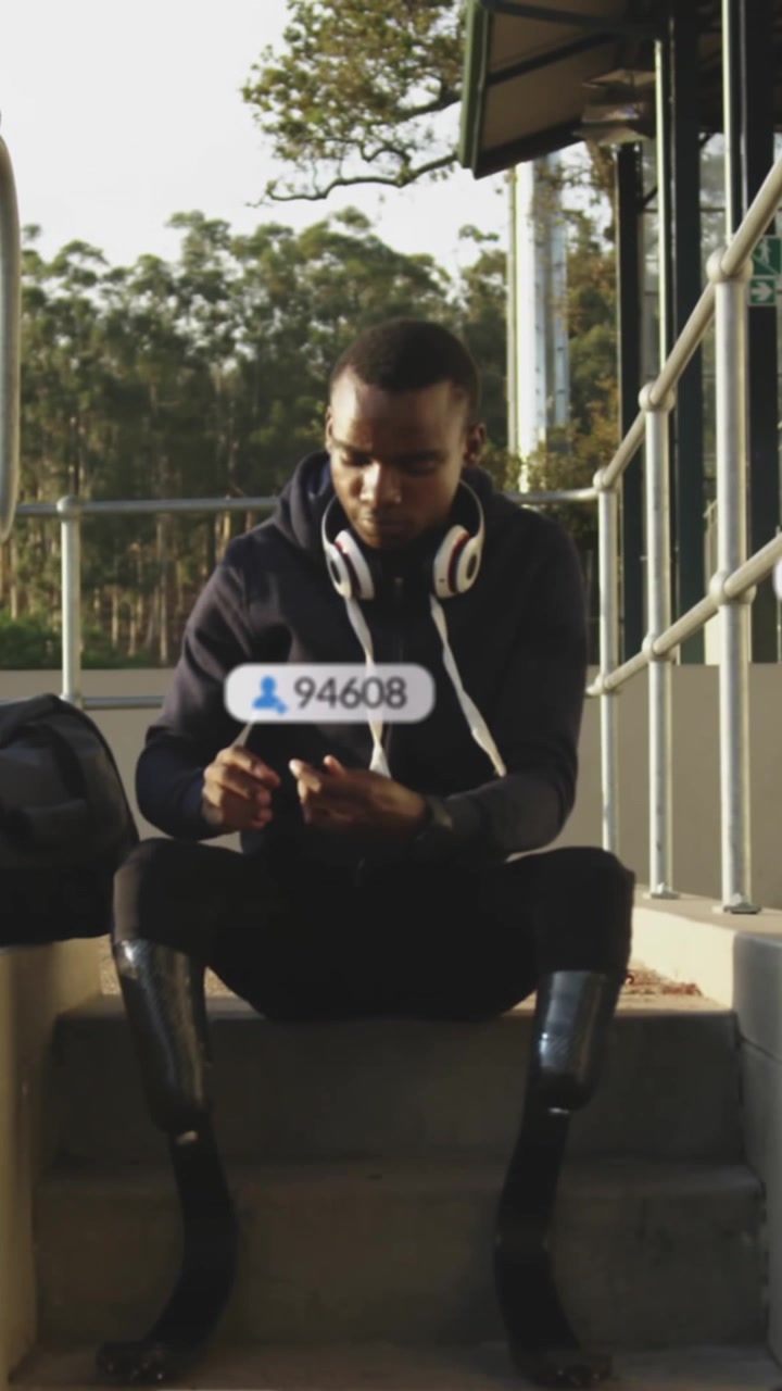 Animation of social media icons over african american man adjusting his prosthetic leg at stadium