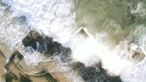 Olas-Blancas-Rodando-Sobre-Algas-Cubiertas-De-Lecho-Horizontal-Rocas-Sedimentarias-Del-Océano-Vista-Aérea-Turimetta-Beach-Sydney-Australia