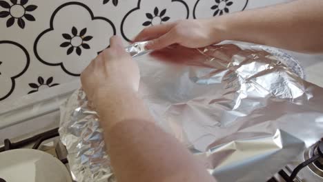 covering hot pot with indian biriyani rice with foil paper