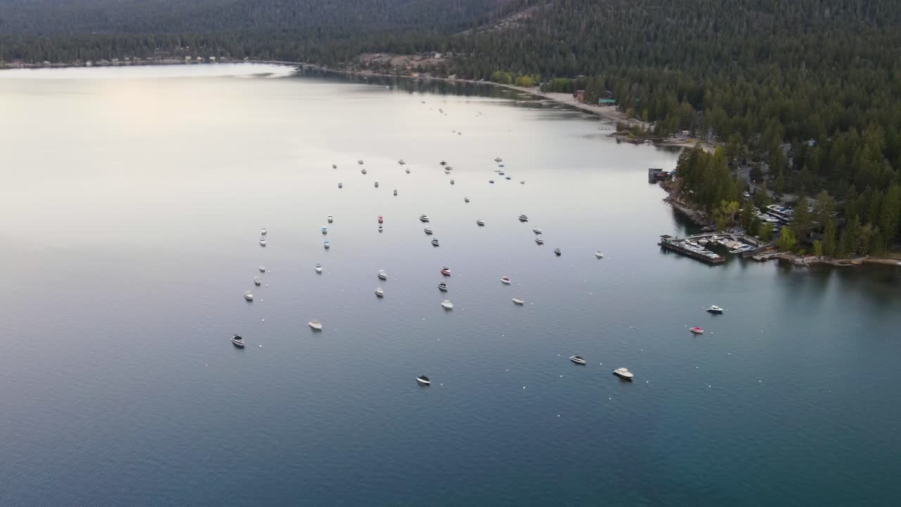un dron de alto vuelo, de 4k, disparado sobre barcos anclados durante una puesta de sol de verano, frente a la costa del lago tahoe, california