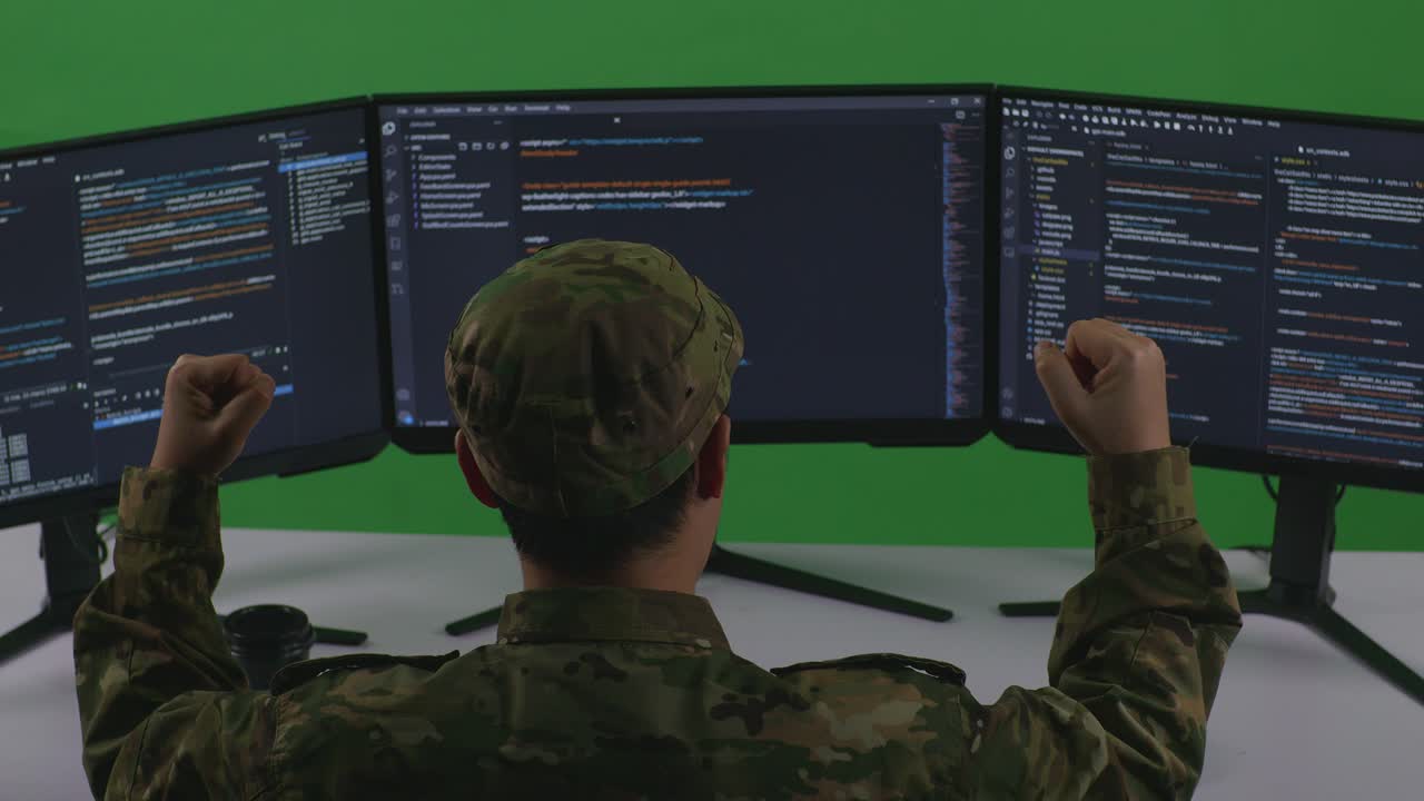 Back View Of Happy Asian Man Soldier Developer Celebrating And Dancing While Write Code With Multiple Computer Screens In Green Screen Studio
