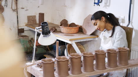 joven mujer afroamericana trabajando en una rueda de cerámica en un estudio de cerámica