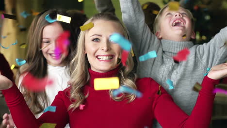 a blonde mother and her two children enjoying a confetti shower