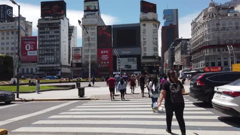 pov crossing 9 de julio, widest avenue in latin america, next to obelisk, business center of buenos aires city argentina at daylight