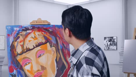 artist examining a painting in a gallery