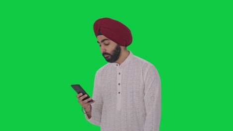 lazy sikh indian man using phone green screen