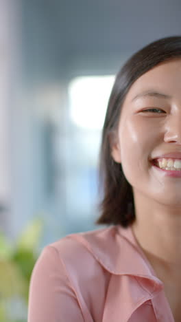 vertical video of portrait of asian businesswoman smiling at office, slow motion