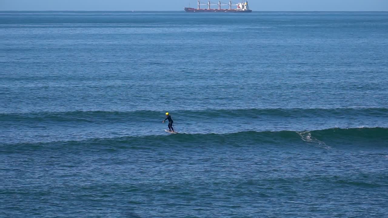 Static view of a surfer with his jet surf jumping on the waves. Daylight