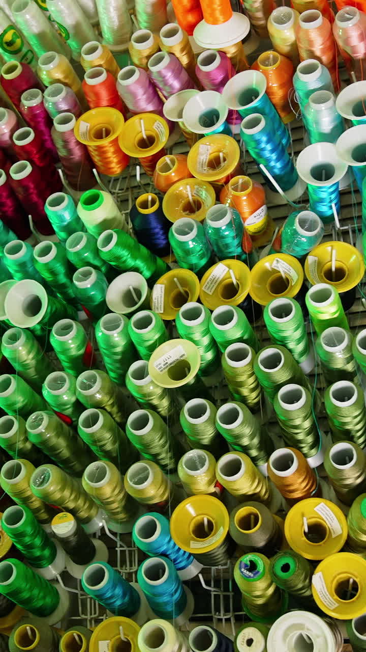 Colorful sewing tools on a wall. Rolls of threads hanging on a wall. Vertical video