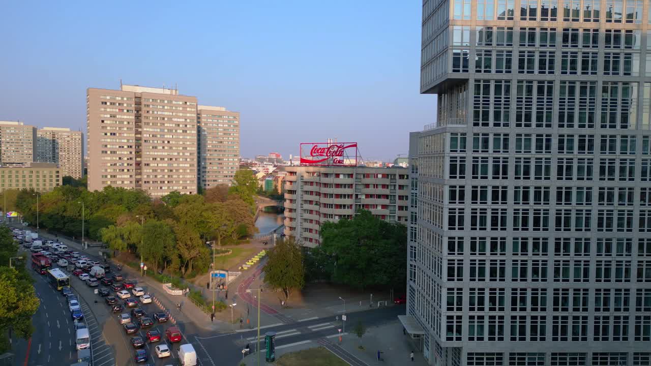 Berlin cityscape with residential buildings, a coca cola billboard, and cars moving along the streets. Unbelievable aerial view flight fly push forward drone