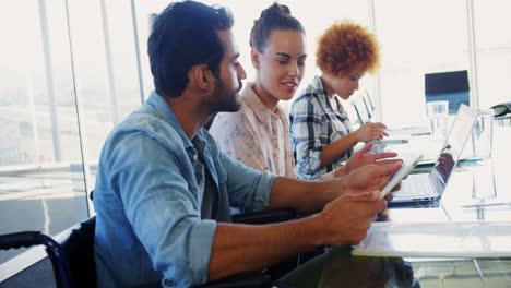 Executives-discussing-over-laptop-in-office