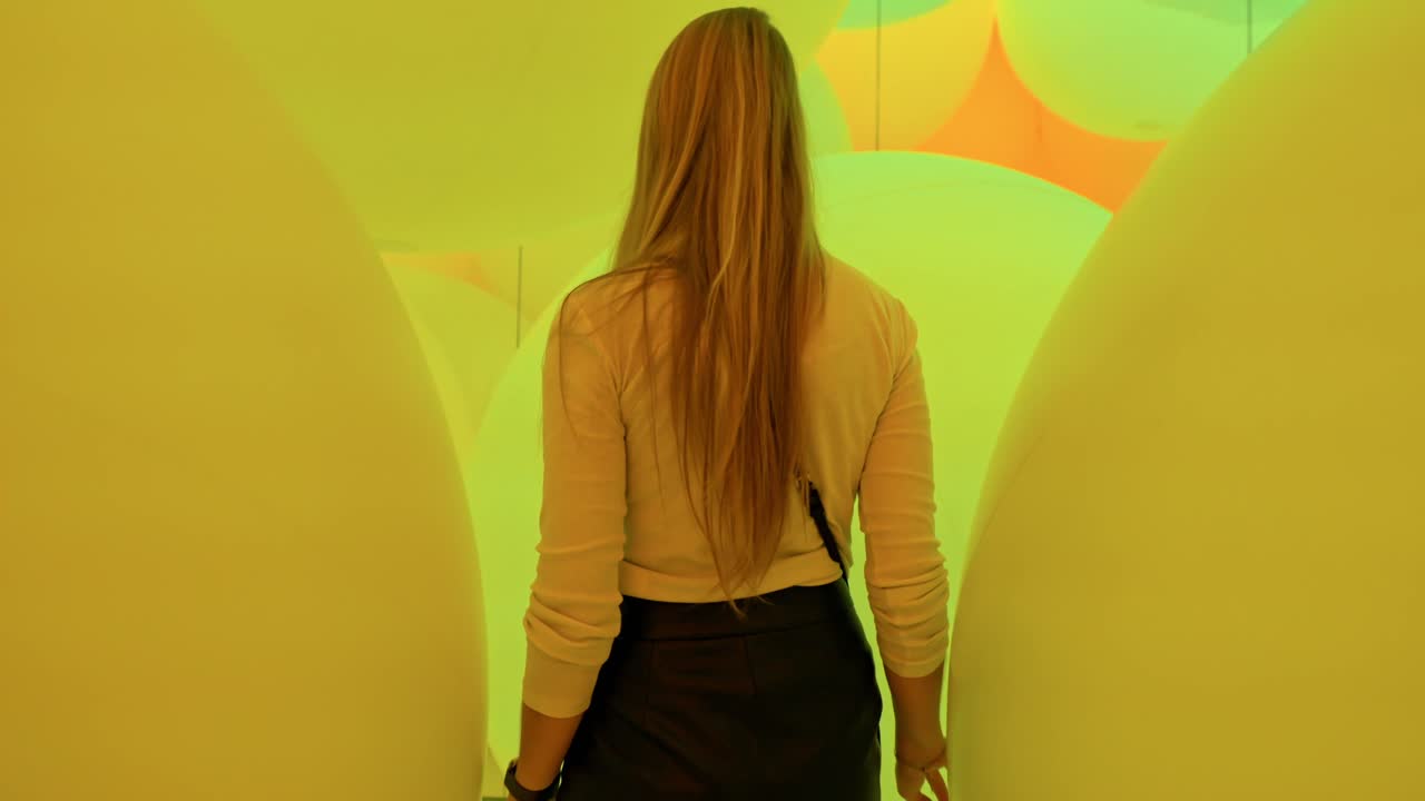 A captivating moment as a girl strolls through an immersive installation of glowing lightning balls at TeamLab Planets, Tokyo.