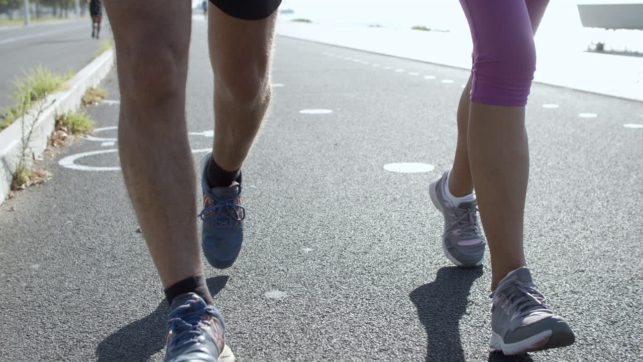 아스팔트 도로에서 달리는 남성과 여성의 다리