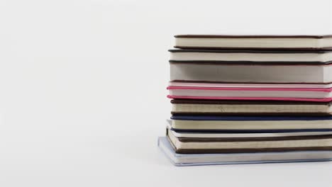 close up of stack of books on white background, in slow motion