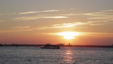 boats move across the water at a golden sunset, slow motion