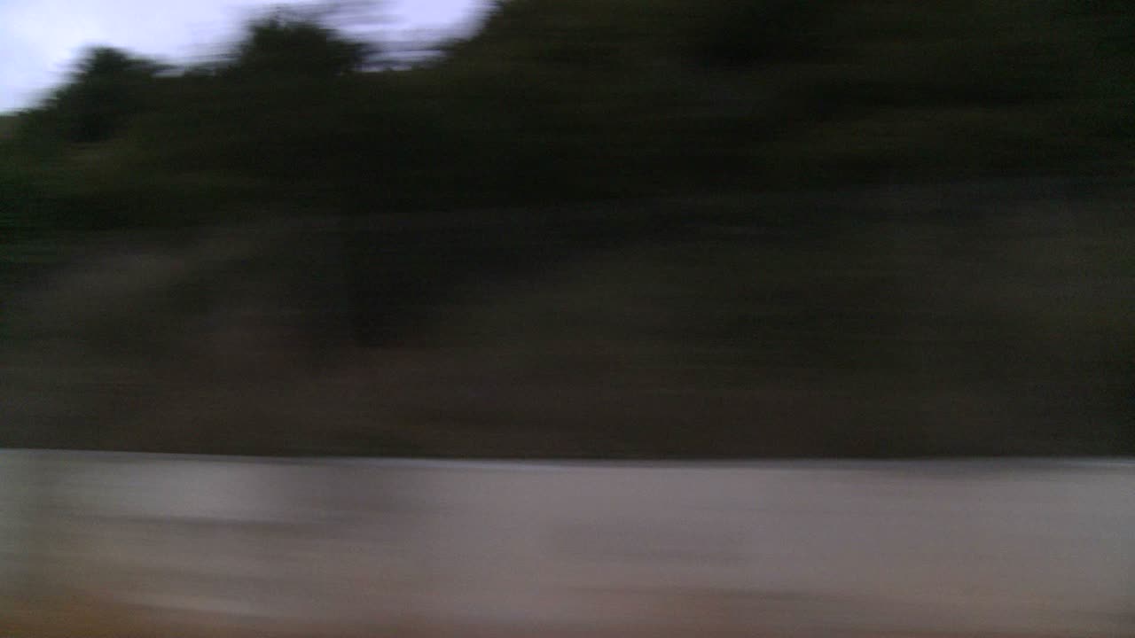 un automóvil viaja a lo largo de la autopista de la costa del pacífico temprano en la mañana o tarde en la noche como se ve a través de la ventana lateral