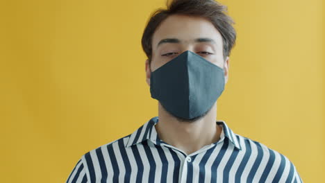 man wearing a face mask on a yellow background