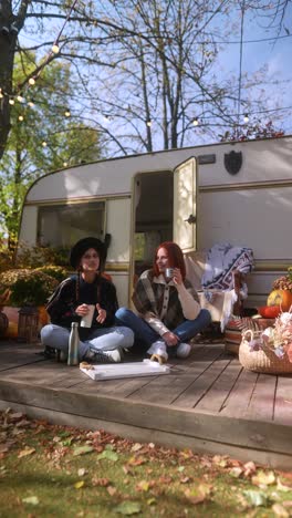 friends enjoying a relaxing autumn afternoon by a vintage campervan