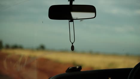 abstract handheld shot inside vehicle, focus on rearview mirror