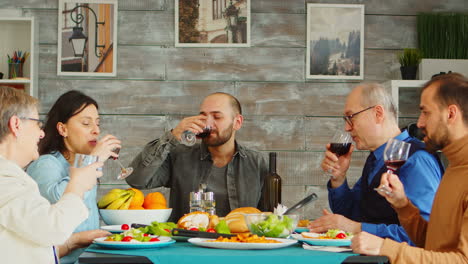 Multigenerational-family-clinking-wine-glasses-at-sunday-dinner